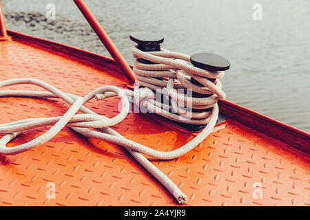 Bollard et corde d'amarrage rouge sur la surface métallique de bateau. Concept de voyage Banque D'Images