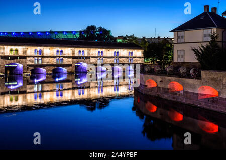 Le Barrage Vauban illuminés à la tombée de la nuit à Strasbourg, en France, un travail défensif sur l'Ill dans le quartier historique de la Petite France. Banque D'Images