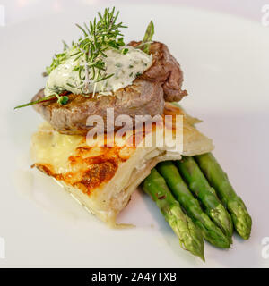 Angus farci aux pommes, asperges et Boulangerre Paris beurre, le romarin, les fèves germées et les jeunes feuilles de betterave. Vue de côté. Banque D'Images