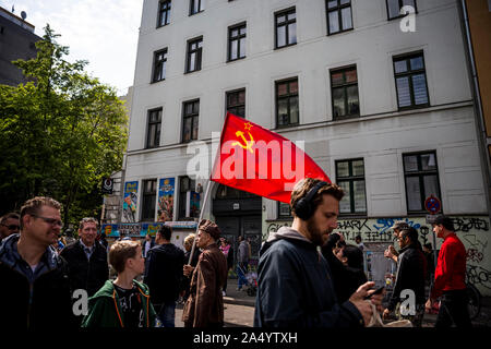 Un homme âgé en uniforme militaire porte un drapeau communiste pour le premier mai 2019 à Berlin, Allemagne Banque D'Images