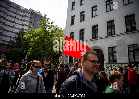 Un homme âgé en uniforme militaire porte un drapeau communiste pour le premier mai 2019 à Berlin, Allemagne Banque D'Images