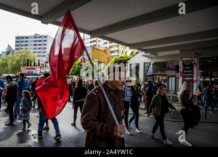 Un homme âgé en uniforme militaire porte un drapeau communiste pour le premier mai 2019 à Berlin, Allemagne Banque D'Images