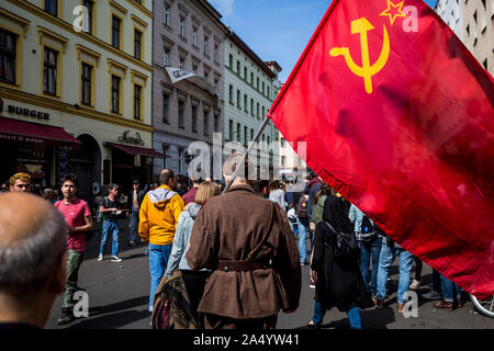 Un homme âgé en uniforme militaire porte un drapeau communiste pour le premier mai 2019 à Berlin, Allemagne Banque D'Images