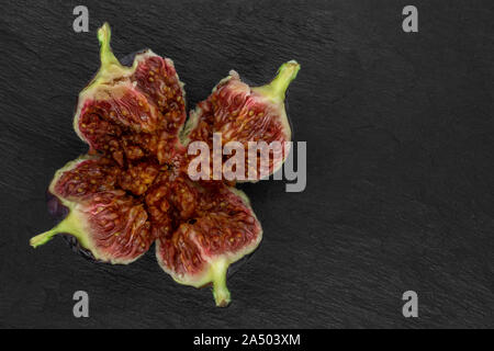 Vue de dessus du commun déchirés fig (Ficus carica) fruits sur fond noir en noir avec copie espace Banque D'Images