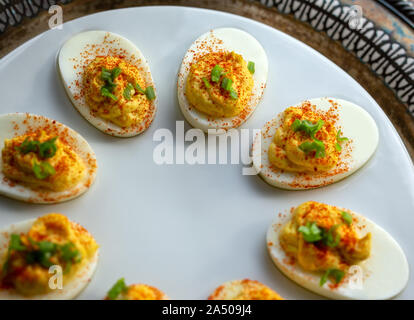 Oeufs farcis sur un plateau blanc et planche à découper. Banque D'Images