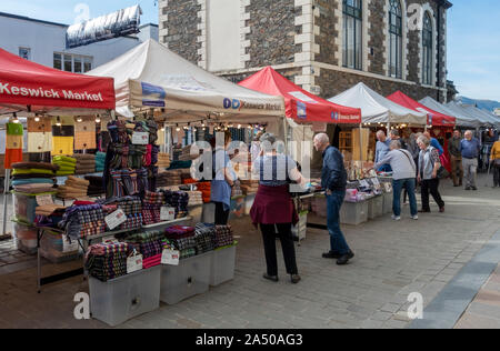 Les touristes les visiteurs regardant à l'extérieur marché stalles dans l'été Market Square Keswick Cumbria Angleterre Royaume-Uni Grande-Bretagne Banque D'Images