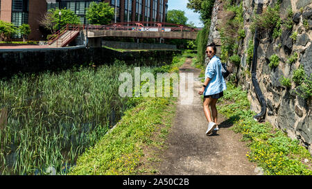 Femme marchant dans toepath canal à Georgetown, DC tournant autour de regarder l'appareil photo Banque D'Images