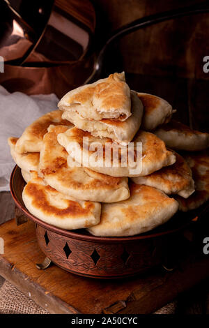 La nourriture traditionnelle russe ukrainien pirozhki petite partie graphique avec la pomme de terre. Banque D'Images