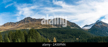 Un paysage de montagne avec panorama forêt de pins verts et des sommets enneigés en automne Banque D'Images