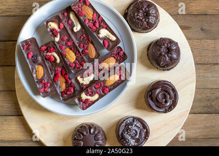 Dessert au chocolat cru végétalien sain. Délicieux bâtons faits maison et des bonbons avec des framboises, amandes et noix de cajou. Arrière-plan de concept d'aliments sains Banque D'Images