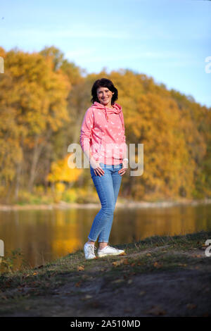 Jeune fille dans une forêt d'automne jaune. Belle jeune femme marche sur le chemin de la forêt d'automne. Banque D'Images