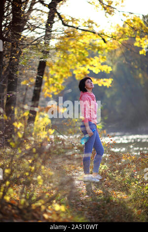 Jeune fille dans une forêt d'automne jaune. Belle jeune femme marche sur le chemin de la forêt d'automne. Banque D'Images