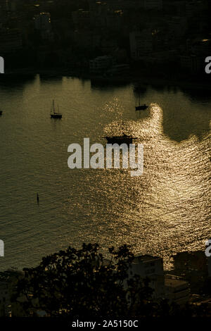 Clé faible vue aérienne de la baie de Saranda, Albanie, dans la riviera albanaise avec coucher de soleil reflets de lumière dans l'eau de mer et des silhouettes de navires et bateaux dans la baie Banque D'Images