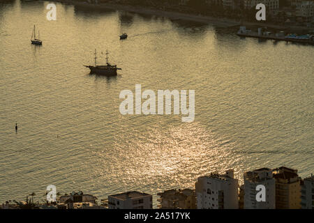 Clé faible vue aérienne de la baie de Saranda, Albanie, dans la riviera albanaise avec coucher de soleil reflets de lumière dans l'eau de mer et des silhouettes de navires et bateaux dans la baie Banque D'Images