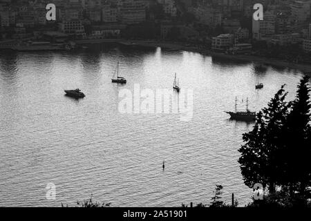 Clé faible vue aérienne de la baie de Saranda, Albanie, dans la riviera albanaise avec coucher de soleil reflets de lumière dans l'eau de mer et des silhouettes de navires et bateaux dans la baie Banque D'Images