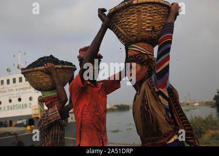 Dhaka, Bangladesh. 17 Oct, 2019. Transporter le charbon comme ils ouvriers de décharger un navire à bord d'une rivière dans la périphérie de Dacca. Credit : MD Mehedi Hasan/ZUMA/Alamy Fil Live News Banque D'Images
