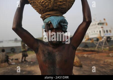Dhaka, Bangladesh. 17 Oct, 2019. Un manoeuvre décharger le charbon sur la tête d'un navire près d'une rivière dans la périphérie de Dacca. Credit : MD Mehedi Hasan/ZUMA/Alamy Fil Live News Banque D'Images