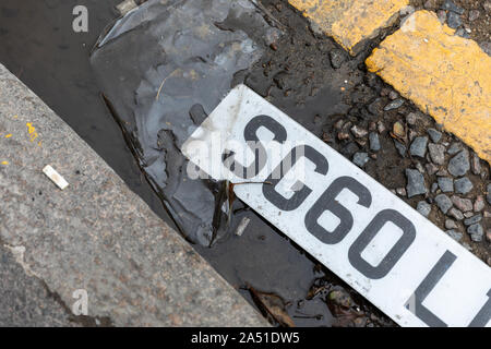 Une plaque d'établit dans une flaque d'eau sur une rue de la ville Banque D'Images