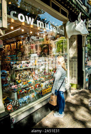 Shopping dans la fenêtre d'une femme, en regardant des cadeaux inhabituels du célèbre musée de la vache d'Amsterdam. Banque D'Images