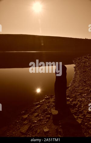 le lever du soleil sépia se reflète sur une surface de miroir d'eau Banque D'Images