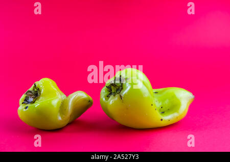 Ugly nourriture. poivron vert sur fond rouge. copy space Banque D'Images