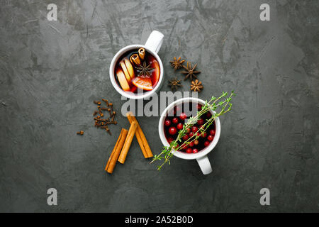 Vin chaud de Noël verre dans une tasse avec les agrumes orange,apple,des bâtons de cannelle et les étoiles d'anis sur fond de béton gris foncé top view Banque D'Images