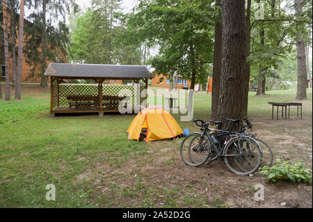 Les touristes cyclistes camping, deux vélos et un touriste jaune tente, Nesterovsky Marinovo village, district, région de Kaliningrad, Russie, le 1 août, 2019 Banque D'Images