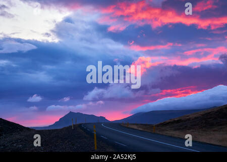 Panneaux route dans l'ouest de l'Islande, de Snæfellsnes au coucher du soleil avec une lumière, le ciel, les nuages et les montagnes derrière les couleurs Banque D'Images