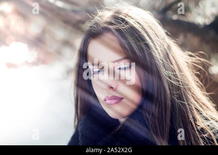 Belle femme avec les yeux fermés à la lumière du soleil Banque D'Images