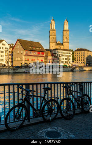 Les vélos garés sur les rives de la Limmat avec Grossmunster cathédrale en arrière-plan, Zurich, Suisse Banque D'Images
