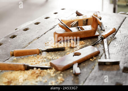 Workbench avec différents outils à main dans un atelier de menuiserie bois ou des ciseaux à bois, y compris et d'un maillet dans une vue en gros plan Banque D'Images