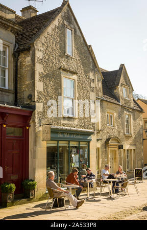 Assis à l'extérieur de l'épicerie à la fin de l'hiver soleil dans la grande rue Corsham Wiltshire England UK Banque D'Images