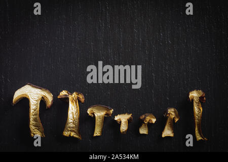 Tranches de champignons séchés savoureux sur fond noir en noir. Vue d'en haut. Banque D'Images