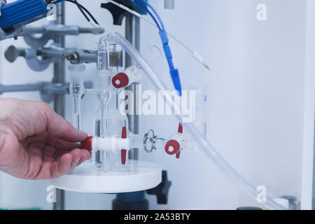 Main d'un jeune chercheur scientifique femelle avec le comprimé dans un laboratoire Banque D'Images