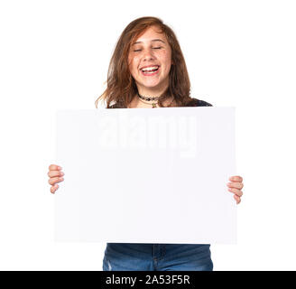 Studio shot of Horizontal un rire fille préadolescente holding a blank panneau blanc isolé sur blanc. Banque D'Images