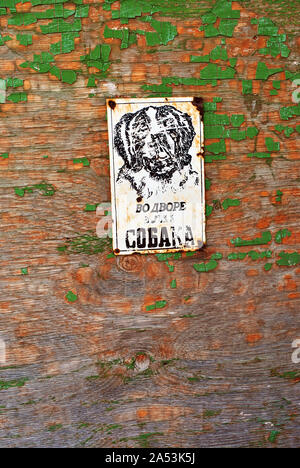 Planches en bois peint vert glauque close up detail surface avec signe avec l'inscription en russe 'chien en colère dans la cour' et le chien face noire, grunge Banque D'Images