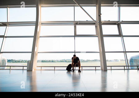 Voyageur à l'aéroport d'attente déprimé après les retards et annulations de vols Banque D'Images