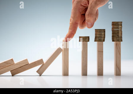 Portrait Of Businessman's hand protection Coins de tomber tout en jouant sur la table Domino Banque D'Images