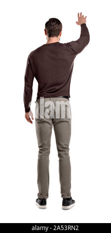 Mettre en place un homme en Pull décontracté se trouve dans la vue arrière avec un bras levé jusqu'à attirer l'attention sur lui. Banque D'Images