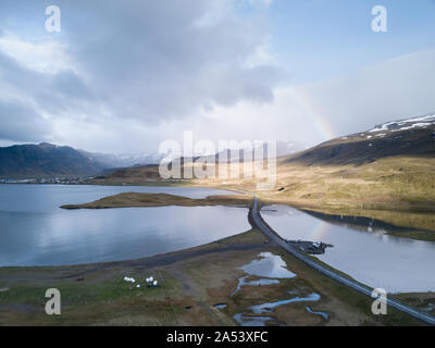 Une vue aérienne d'un arc-en-ciel se reflétant dans les eaux d'une baie en Islande. Banque D'Images