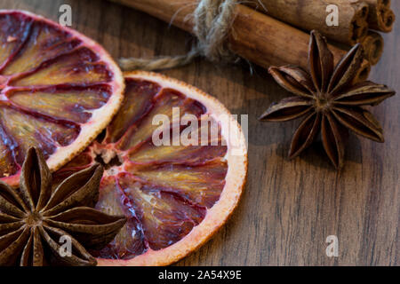 Orange sicilienne séché et séchés tranche de citron avec des bâtons de cannelle et anis étoile sur fond de bois brun, Close up. Macro. Ambiance de Noël backgroun Banque D'Images