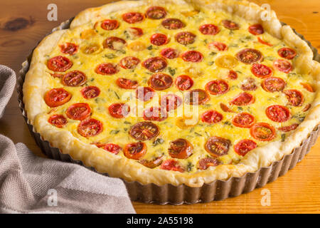 Tarte aux tomates cerises et des oeufs dans de l'étain sur table en bois - selective focus photo Banque D'Images