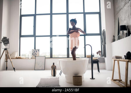À jambes longues Slim femme laissant bain après l'avoir dans la matinée Banque D'Images