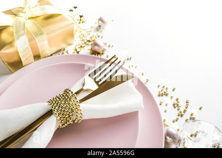 L'élégance de Noël table avec vaisselle, couverts d'or rose sur fond blanc. Vue d'en haut. Le dîner de Noël. Banque D'Images
