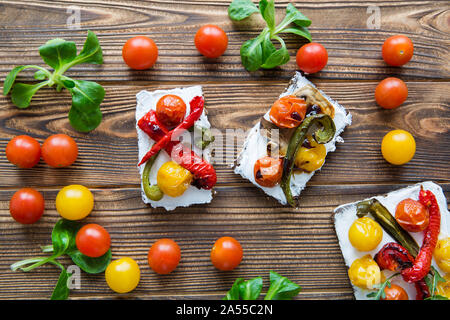 Collation santé et savoureux bruschettas avec légumes grillés et fromage sur la table en bois brun. Vue d'en haut. Banque D'Images