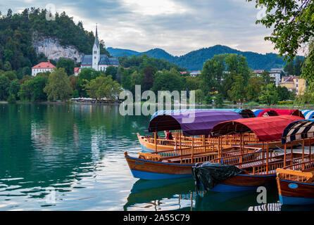 Pletna les bateaux traditionnels en bois sur le lac de Bled avec l'église de Sainte Marie de l'assomption sur l'île de Bled en Haute-carniole, Slovénie Banque D'Images