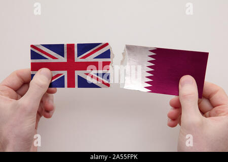 Le Royaume-Uni et le Qatar drapeaux en papier déchiré concept relations politiques. Banque D'Images