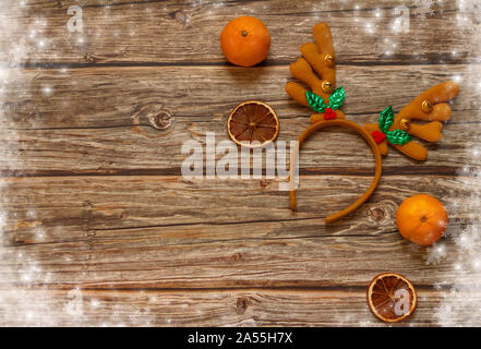 Arrière-plan en bois avec décoration cerf de Noël bois et mandarines sur la table. Cadre vacances d'hiver. Vue de dessus de la couche à plat. Espace de copie Banque D'Images