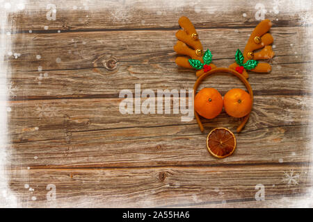 Arrière-plan en bois avec décoration cerf de Noël et mandarines sur la table. Cadre vacances d'hiver. Vue de dessus de la couche à plat. Espace de copie Banque D'Images