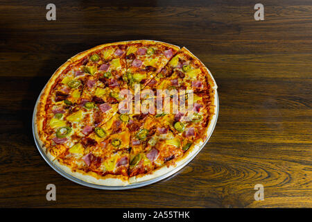 American pizza à l'ananas et au jambon sur table en bois. Banque D'Images